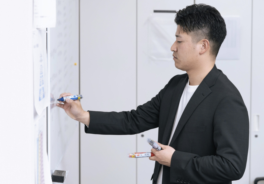 研修の一環として、社員がホワイトボードを使いながら知識やノウハウを共有し、実践的な学びを行っている様子